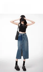 Detail of high-waist denim midi skirt with patchwork pockets and front slit design