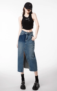 Detail of high waist denim skirt featuring color block patchwork and a front high slit