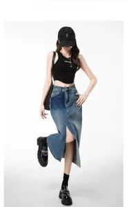 Detail of high-waist denim maxi skirt featuring contrast paneling and front split detail