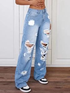 Detailansicht großer Risse und ausgefranster Kanten an hellblauen Denim-Jeans