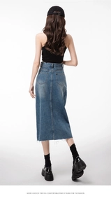 Detail view of high waist denim skirt back with dual pockets and frayed hemline edge