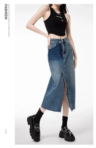 Detail view of denim skirt with high center slit and frayed edges for trendy women