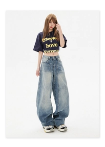 Detail of high waisted wide leg jeans with vintage wash and raw hem for street style
