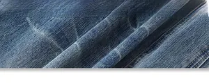 Close-up of deep blue denim fabric with orange double stitching and twill texture details