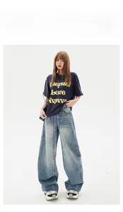 High-waist wide-leg blue jeans styled with dark navy graphic T-shirt and sneakers