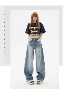 Detail of high-waisted wide-leg jeans with vintage wash and unique front seam stitching