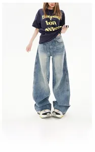 Detail of high waist wide leg jeans featuring retro light wash and distressed whisker texture