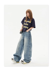 Close-up of oversized light blue washed denim pants with street style loose wide leg fit
