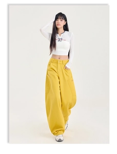Détail du pantalon cargo jaune à taille haute, jambes larges et grandes poches latérales