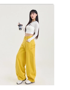 Détail du jean jaune taille haute à jambes larges avec poches latérales et broderie de lettres