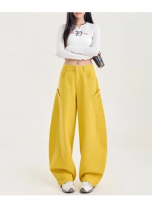 Détail du pantalon cargo jaune oversize avec broderie de lettres et grandes poches
