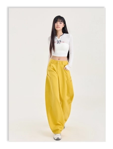 Détail du haut court blanc avec broderie 77 et pantalon cargo jaune à jambes larges