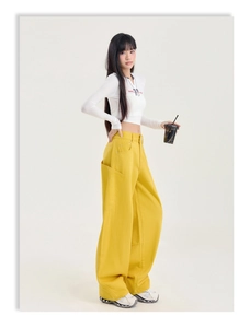 Détail d'un pantalon cargo jaune taille haute et d'un haut court blanc assorti