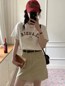Close-up of a white graphic t-shirt and khaki A-line utility skirt for a trendy outfit
