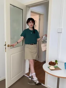 Detail of a casual Japanese style outfit with a dark green tee and khaki cargo skirt