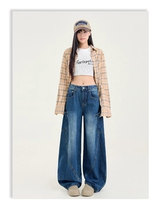 Détail d'un jean large délavé vintage avec poches cargo latérales et broderie lettrée