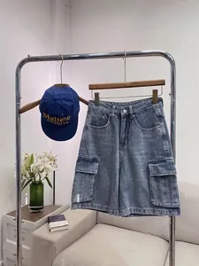 Detail of retro washed denim cargo shorts in navy blue with oversized utility side pockets