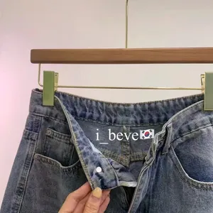 Detail of vintage blue washed denim shorts featuring multi-pocket design and metal button