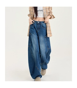 Détails du jean baggy montrant le lavage, le design patchwork et les surpiqûres contrastées