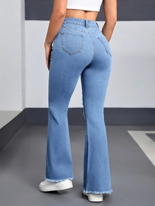 Detail of high-waisted flared jeans featuring raw hems and stylish fringed edges