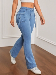 Dettaglio dei jeans a zampa a vita alta con tasche cargo e fibbie metalliche decorative