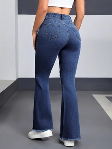 Close-up of the back view of flared jeans with heart-shaped pockets and raw hem edges