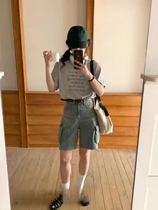 Detail of casual high-waist denim cargo shorts with functional side pockets and loose fit