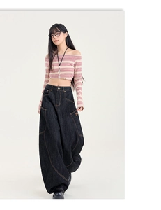 Détail d'un jean baggy ample avec coutures incurvées et broderie dorée sur la poche