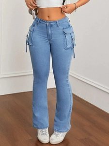 Dettaglio di jeans a zampa a vita alta celeste con tasche cargo e fibbie metalliche decorative