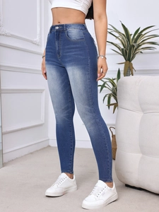 Dettaglio dei jeans skinny blu elasticizzati con effetto sbiadito e vita alta