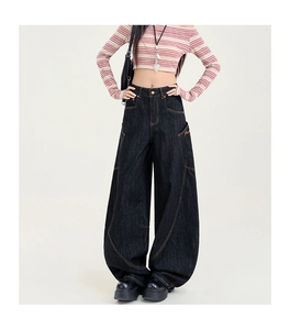 Détails des surpiqûres jaunes et broderies sur le jean en denim à coupe large
