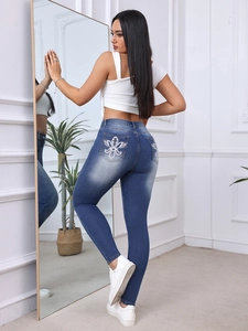 Dettaglio del ricamo floreale sulle tasche posteriori dei jeans slim blu elasticizzati