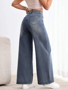 Détail du jean taille haute à jambe large avec poches arrière et texture denim fluide