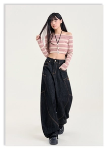 Détail du pantalon en jean foncé ample à taille haute et coutures contrastées orange