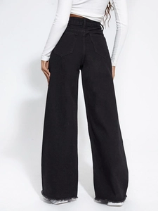 Detail of high waisted black wide leg jeans featuring raw hem and classic back pockets