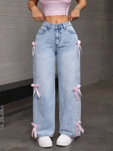 Gros plan sur les nœuds en satin rose sur un jean large bleu clair à taille haute