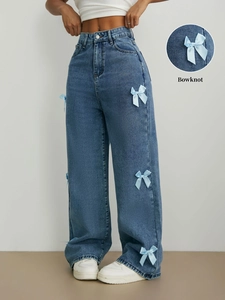 Détail de nœuds en satin bleu clair sur un jean large bleu moyen pour femme
