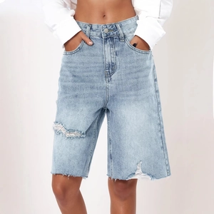 Women's vintage light blue high-waisted denim shorts with ripped details and raw hem edges