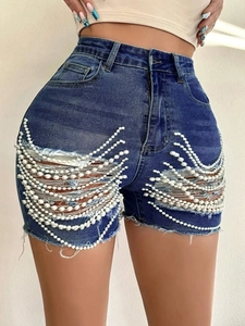 Vue détaillée du short en jean taille haute avec déchirures et franges en perles nacrées