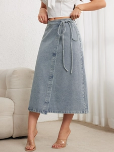 Détail d'une jupe mi-longue en jean bleu clair avec cordon à la taille et couture frontale