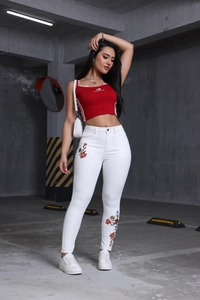 Détail de la broderie florale sur le jean skinny blanc taille haute pour femme