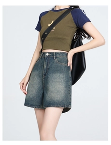 High-waisted wide-leg denim shorts in vintage wash blue shown on model with shoulder bag