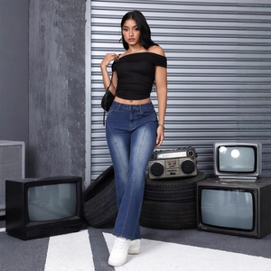 Women's blue flare jeans with patchwork seams and crop top in an industrial setting