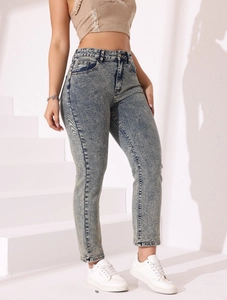 Détail du jean slim taille haute avec texture délavée neige et teinte bleue