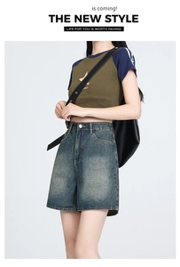 Detail of high-waisted denim shorts with vintage wash effect and retro whisker detailing