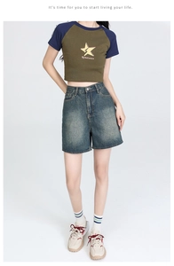Detail of high-waisted vintage wash denim shorts with classic five-pocket design