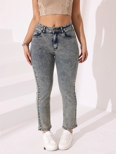 Gros plan détaillé sur le jean taille haute avec délavage neige et effet vintage