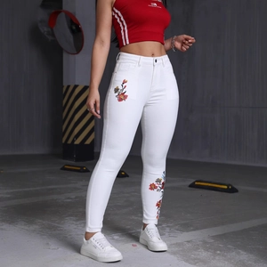 Jean skinny blanc extensible à taille haute avec broderies florales colorées aux jambes