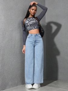 Détail d'un jean taille haute à jambe large avec un haut court à manches longues
