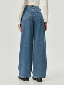 Detailansicht der Gesäßtaschen und der hohen Taille der weit geschnittenen blauen Jeans